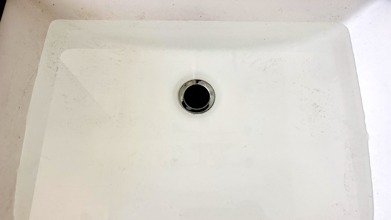 A household sink filled with water from a clogged A/C condensate drain line